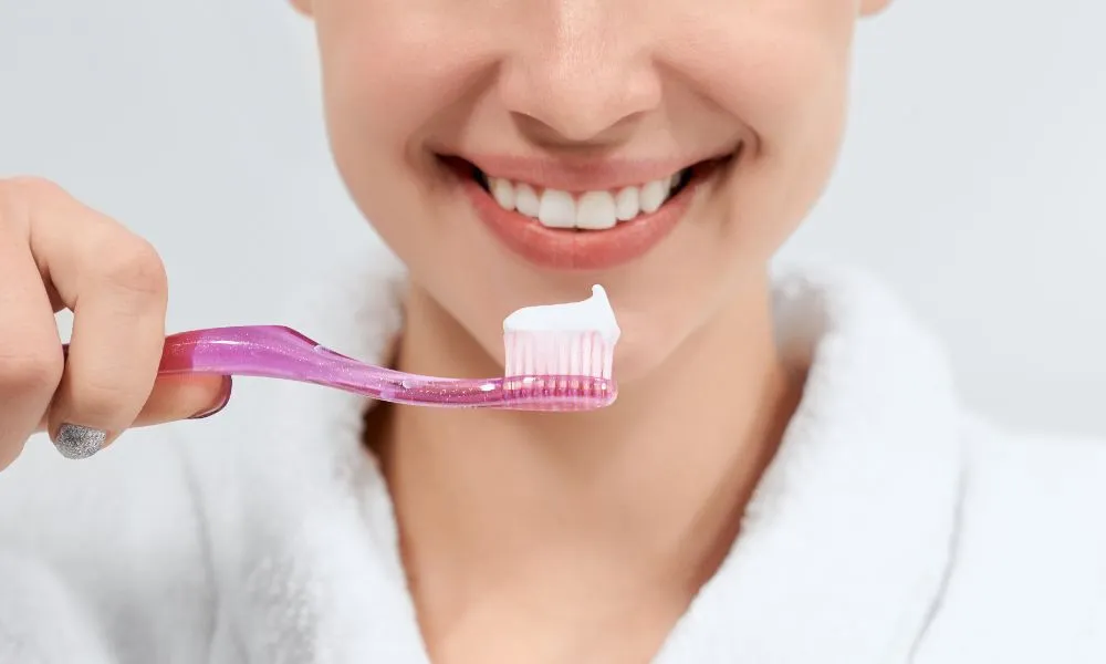 close up of brushing teeth with toothpaste Dallas TX dental care