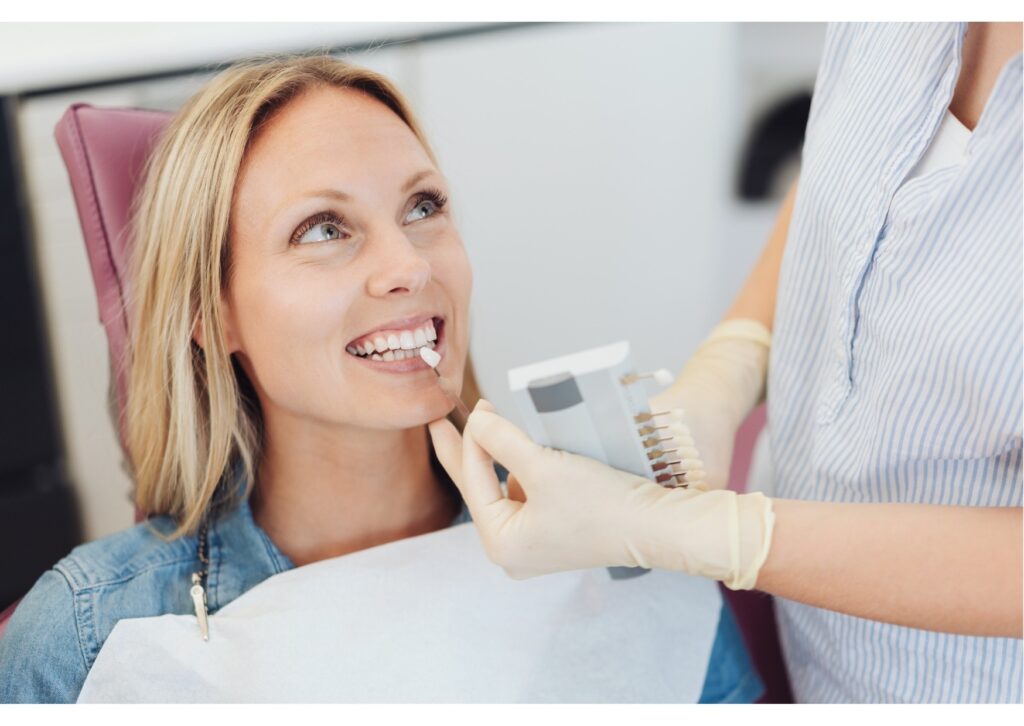Patient comparing tooth shade options during a cosmetic consultation for bonding or veneers