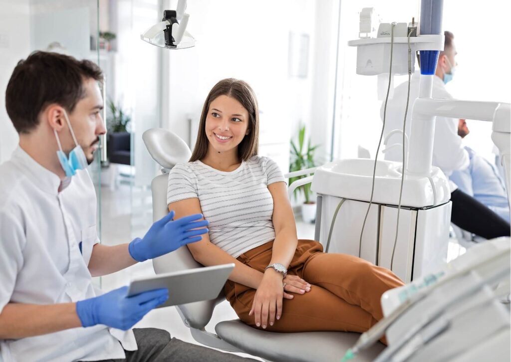 Patient discussing cosmetic treatment options with a dentist, highlighting professional guidance on teeth whitening strips effectiveness and expected whitening results.