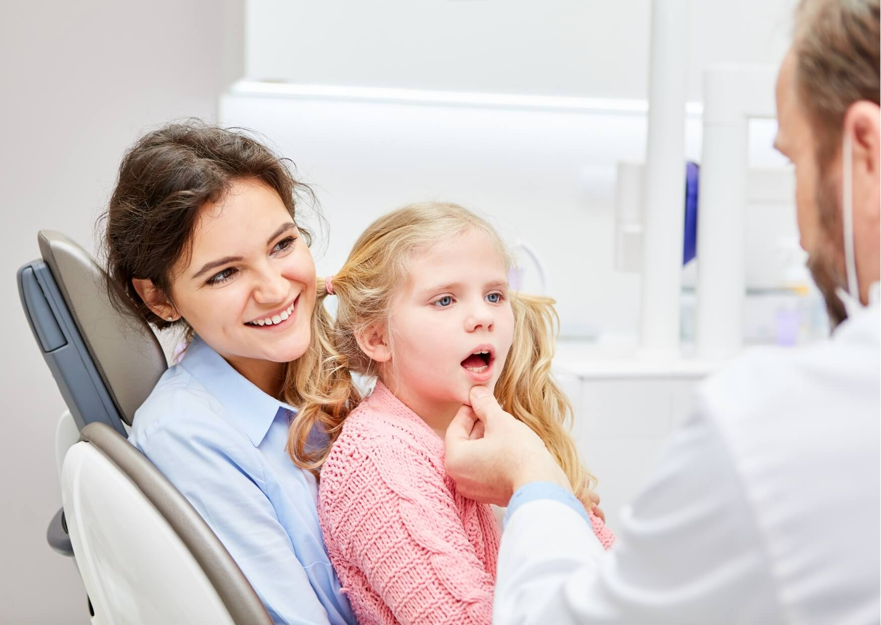 Dentist discussing kids' dental spacers with a parent and child during a pediatric dental consultation.