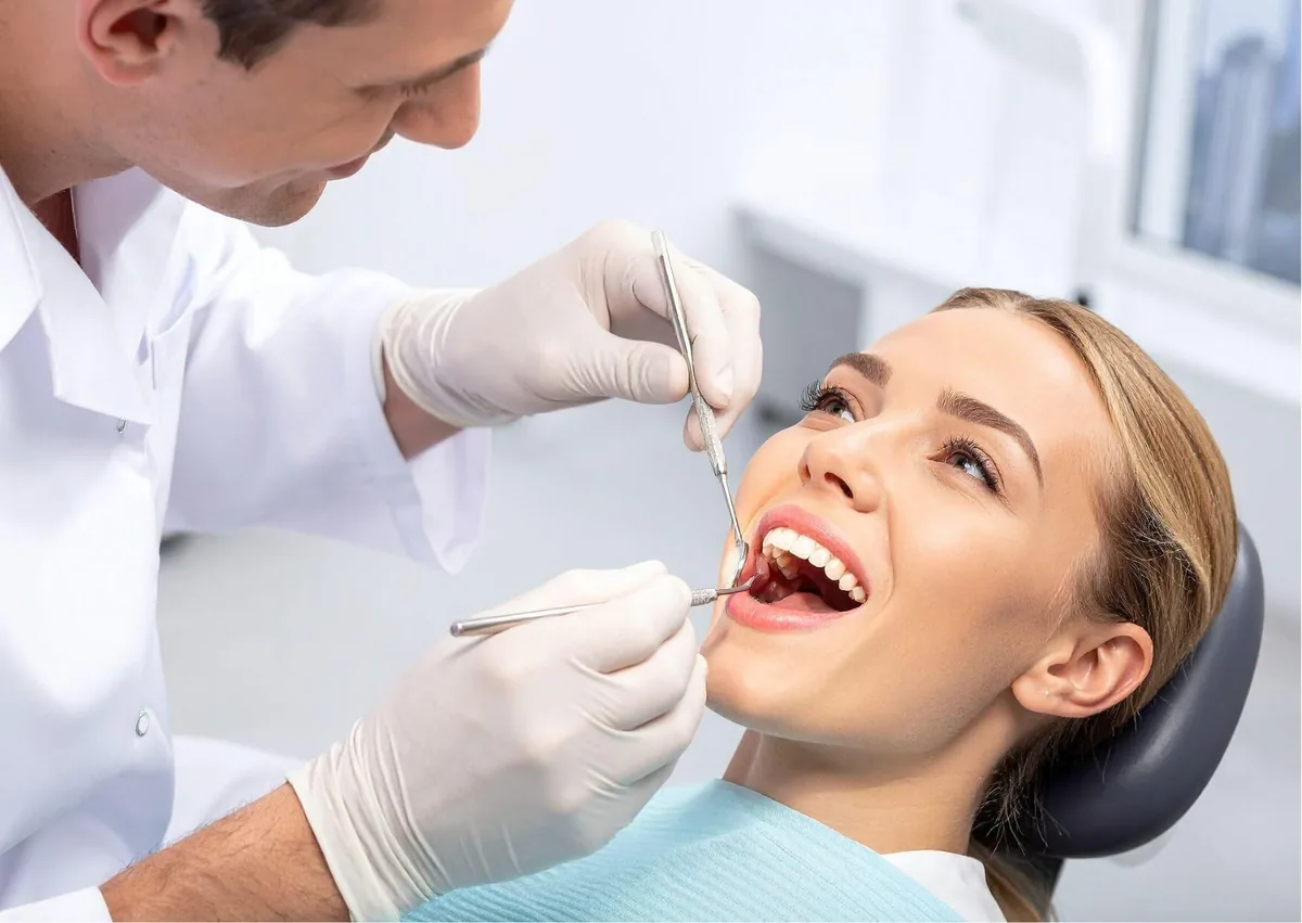Dentist examining a patient’s teeth as part of a smile makeover consultation.