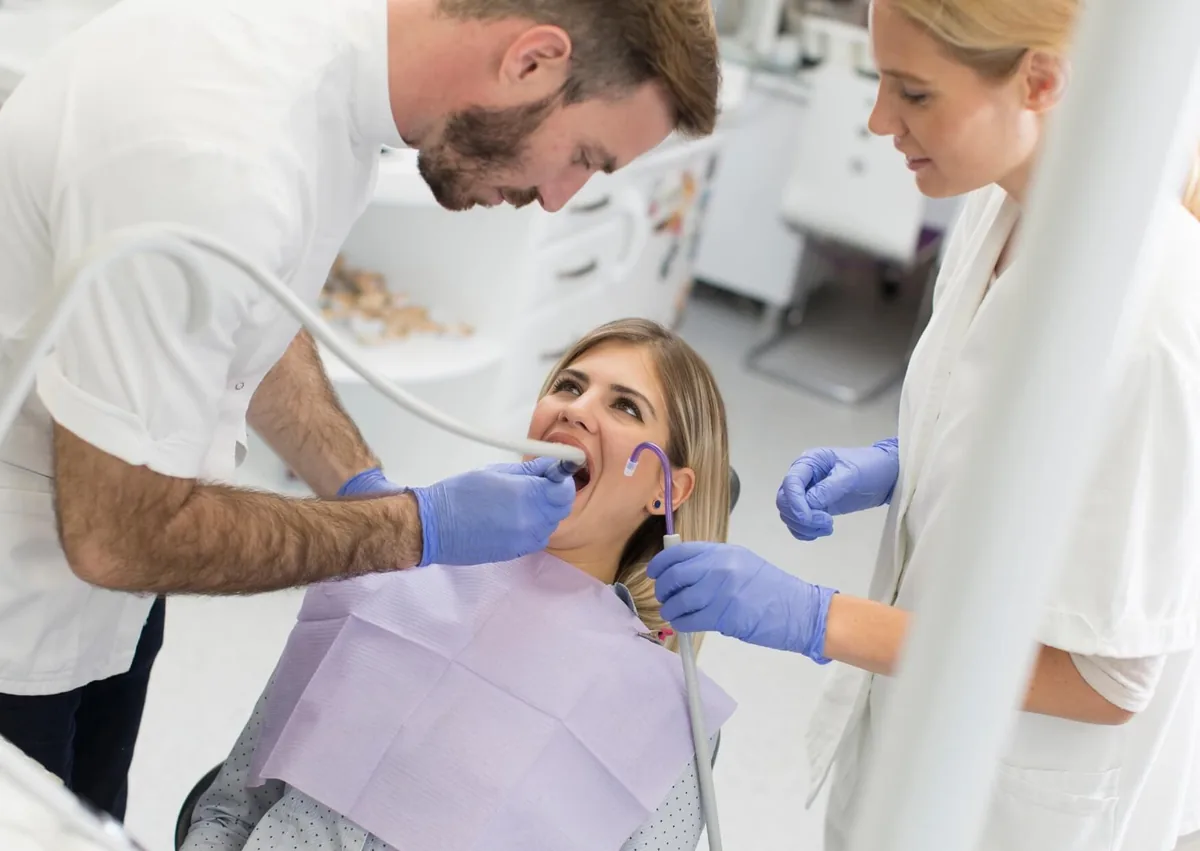 Dental team performing a gum contouring procedure to reshape the gumline around the teeth.
