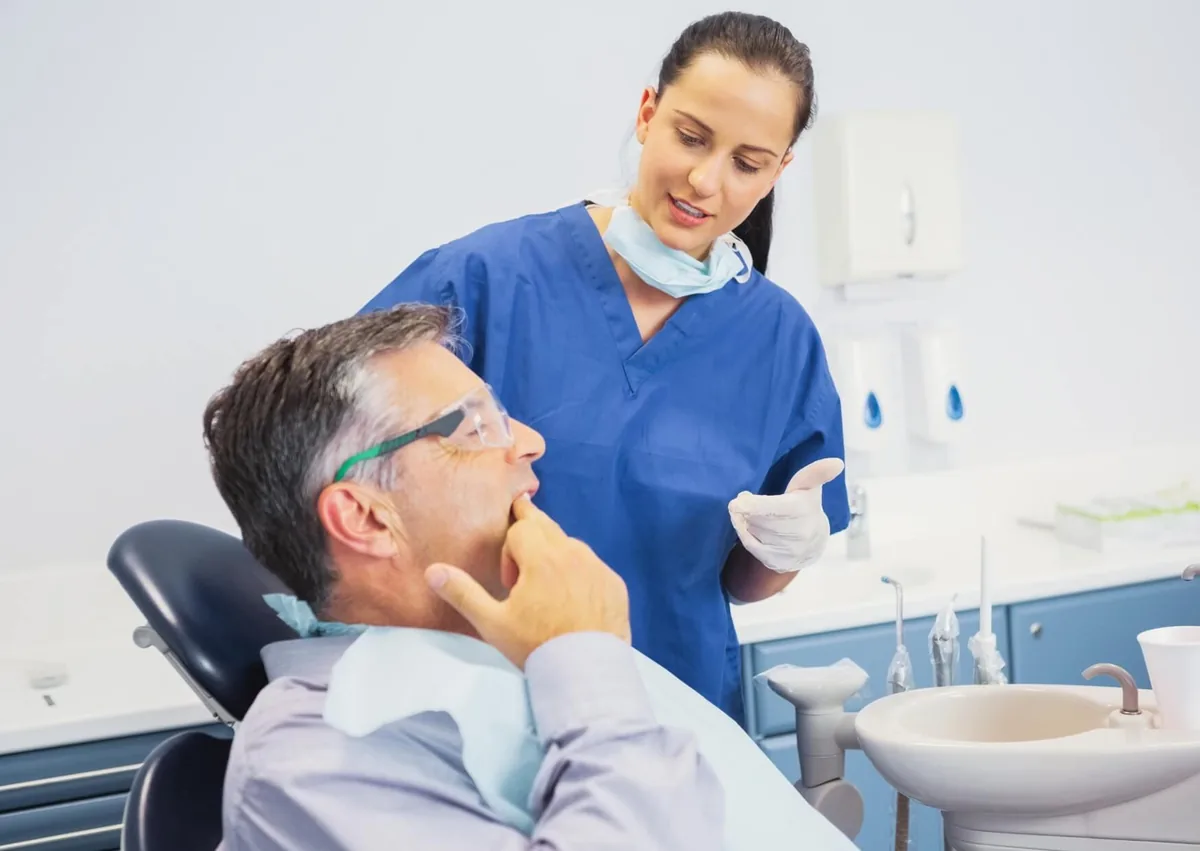 Patient discussing a mouth sore with a dental professional while asking how long canker sores last.